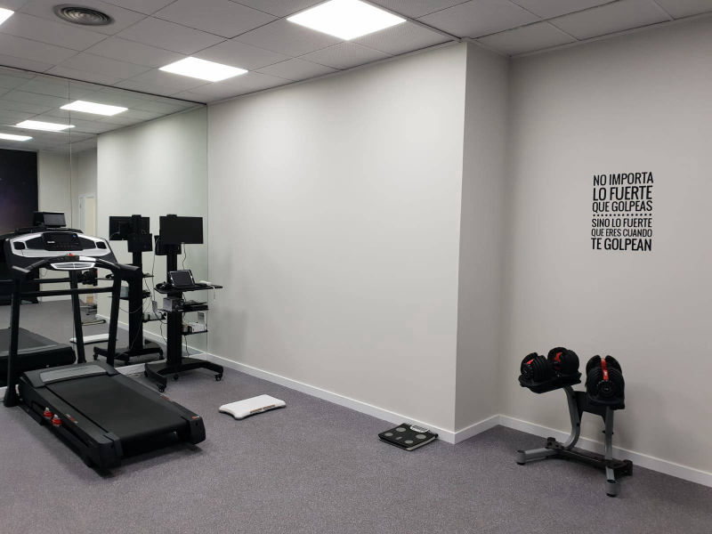 Sala de ejercicio terapéutico con máquinas y pesas